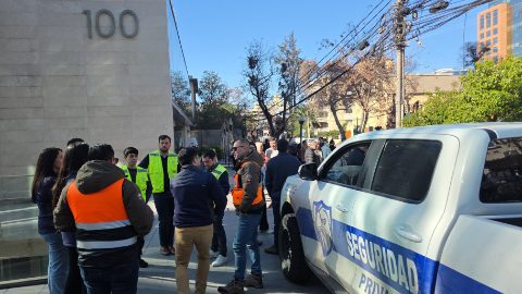 Coordinación en terreno junto a la camioneta de ASCOR Security, frente a un edificio corporativo